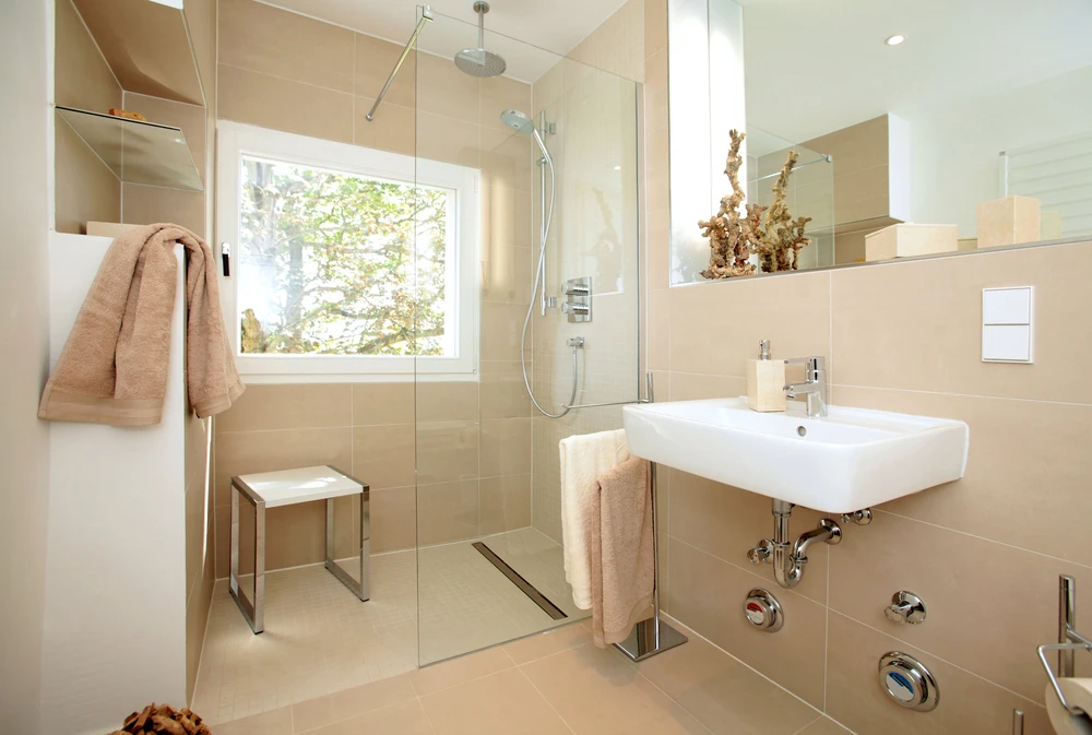 Salle de bain moderne avec douche à l'italienne vitrée, lavabo suspendu blanc et robinetterie chromée